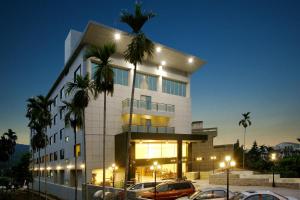 F Hotel - Chiayi في Fanlu: مبنى فيه سيارات تقف امامه