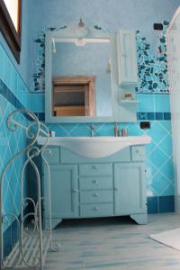 bagno blu con lavandino e specchio di B&B la Pavoncella a Villamar