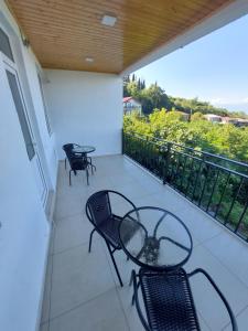 Un balcón con 2 sillas, una mesa y sillas en Apartment in Sighnaghi, en Signagi