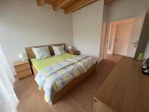 1 dormitorio con 1 cama y suelo de madera en Schwarze Eule Ferienwohnung, en Beckingen