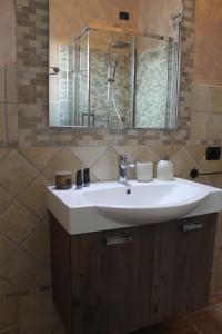 a bathroom with a white sink and a mirror at B&B la Pavoncella in Villamar