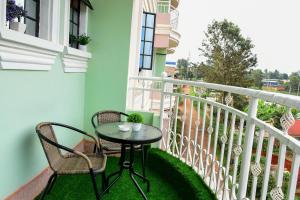 a balcony with a table and chairs on a balcony at Modern & Homely Suite with Free Parking & WiFi in Embu