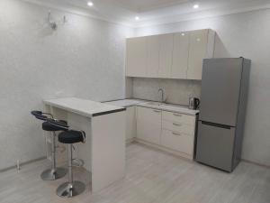 - une cuisine avec un réfrigérateur et deux tabourets dans l'établissement Apartment in Sighnaghi, à Sighnaghi