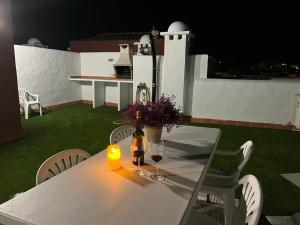 - une table blanche avec une bougie et deux verres de vin dans l'établissement ATICO DUPLEX APARTAMENTO ATLANTERRA PLAYA, ZAHARA DE LOS ATUNES, à Zahara de los Atunes