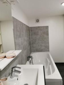 Rougemont的住宿－Studio au calme avec terrasse，浴室配有白色浴缸和水槽