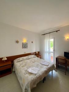 a bedroom with a large bed and a window at Bed & Breakfast Alex in Porto Azzurro