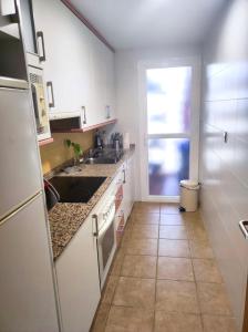 a kitchen with white cabinets and a tile floor at Apartamento Vera playa in Vera