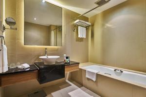 a bathroom with a tub and a sink and a bath tub at Four Points by Sheraton Shanghai, Daning in Shanghai