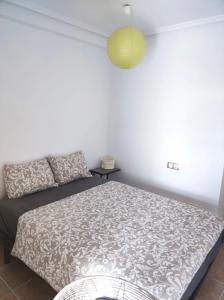a bedroom with a bed and a yellow lamp at Apartamento Vera playa in Vera
