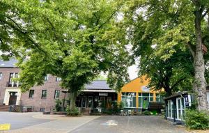 a building on a street with trees in front of it at Gästezimmer Klassen(T)raum in Rheurdt