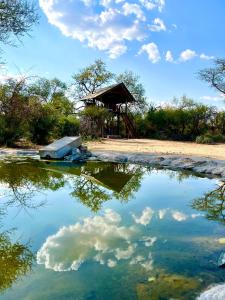 ein Spiegelbild einer Hütte in einem Wasserkörper in der Unterkunft Ondudu Safari Lodge in Omaruru