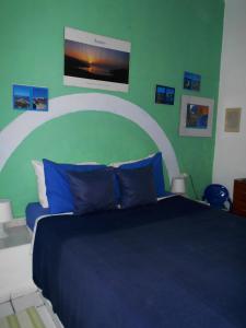 um quarto com uma cama azul e uma parede verde em Meltemia Studios em Marathokampos