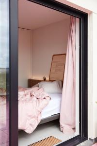 - un miroir réfléchissant le lit dans la chambre dans l'établissement The Pink Penthouse, à La Panne
