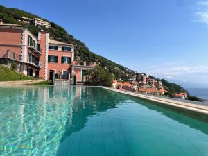 una piscina de agua turquesa en una ciudad con edificios en Villa Bice, en Bergeggi