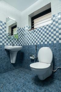 y baño con aseo y lavamanos. en Brookside Heritage Resort, en Kumarakom