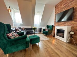 a living room with green furniture and a fireplace at Apartament Zielone Fotele Starówka in Olsztyn