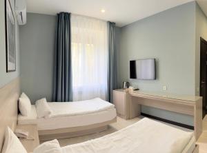 a hotel room with two beds and a television at Resident Hotel Gogol in Almaty