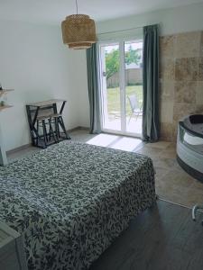 a bedroom with a bed and a sliding glass door at Charme et détente in Allex