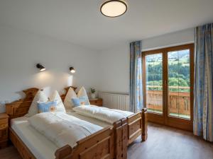 1 dormitorio con 2 camas y ventana grande en Landhaus Geig, en Hopfgarten im Brixental