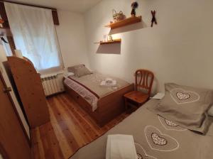 1 dormitorio pequeño con 2 camas y 1 silla en Inmocyma El Sarrau-Cerler, en Cerler
