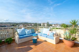 a patio with a blue couch on a balcony at Atico Duplex Pepe y Rosi in Cunit