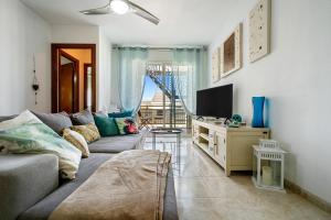 sala de estar con sofá y TV en Atico Duplex Pepe y Rosi, en Cunit