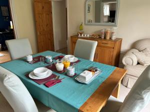 a dining room table with a blue table cloth on it at Everlong Farm in Diss