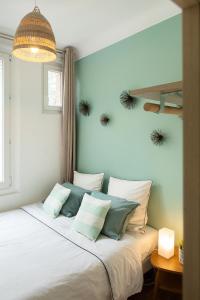 ein Schlafzimmer mit einem weißen Bett mit Kissen darauf in der Unterkunft Magnifique appartement avec une très belle vue sur seine in Boulogne-Billancourt