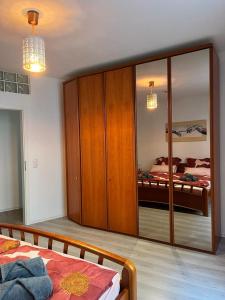 ヴィースバーデンにあるLeonardo Apartmentのベッドルーム1室(鏡付きの大きな木製キャビネット付)