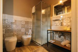 a bathroom with a shower and a toilet and a sink at Agriturismo Agli ulivi in Saluzzo