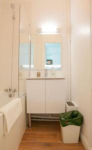Baño blanco con lavabo y espejo en Confortable Studio proche Paris et Eurodisney, en Villemomble