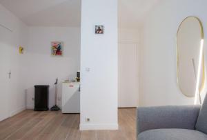 a living room with a chair and a mirror at Confortable Studio proche Paris et Eurodisney in Villemomble