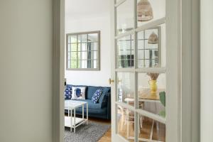 ein Wohnzimmer mit einem blauen Sofa und einem Tisch in der Unterkunft Magnifique appartement avec une très belle vue sur seine in Boulogne-Billancourt