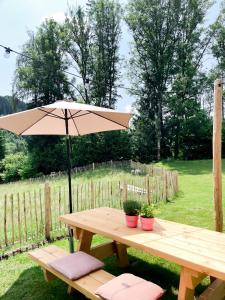 a picnic table with an umbrella in a yard at Arriach Apartments in Arriach