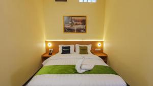 a bedroom with a large bed with two pillows at Urbanview Hotel Sakura Kampung Inggris Pare by RedDoorz in Pare