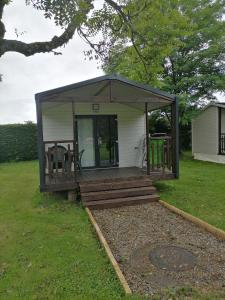 uma pequena cabina com um alpendre e um deque em Camping de masevaux em Masevaux