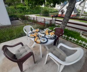 a table with a plate of food on it with chairs at Guesthouse Durmitor Magic in Žabljak