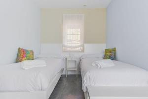 3 camas en una habitación pequeña con ventana en Casa Rural Duran en Mocejón