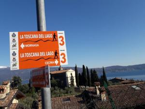 a street sign on a pole in front of some houses at Cà del borgo Historic Village in Toscolano Maderno