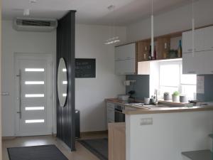 uma cozinha com armários brancos e um frigorífico em ADELINA Apartman 