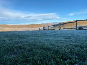 a field of grass with a fence in the background at Twin peaks in Underberg