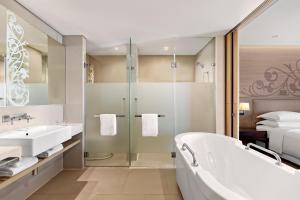 baño con bañera y lavamanos y cama en Four Points by Sheraton Bangkok, Sukhumvit 15, en Bangkok