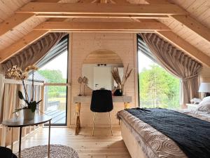a bedroom in a tiny house with a large window at UNO Dom Kopalino in Kopalino