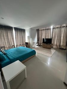 een slaapkamer met een bed en een flatscreen-tv bij The CHU cafe / guesthouse in Nai Harn Beach