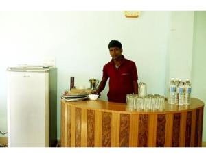 a man standing behind a counter in a kitchen at Tashi Ghatsal, Himachal Pradesh in Kyelang