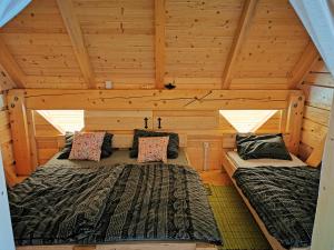 Stari Trg pri LožuにあるDormitory and wooden house Beli gaberのログキャビン内のベッド2台が備わる部屋です。