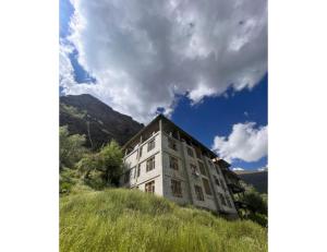 a building on top of a grassy hill at Tashi Ghatsal, Himachal Pradesh in Kyelang