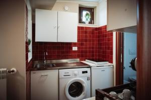 una cucina con lavatrice e lavandino di LA TERRAZZA DEI GEMELLI - casa vacanze a Venosa