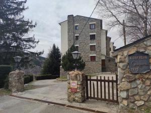 un edificio con una valla y una señal delante de él en Inmocyma El Sarrau-Cerler, en Cerler