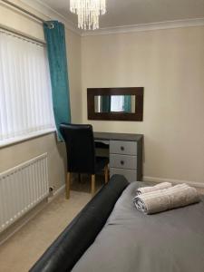 a bedroom with a bed and a desk with a mirror at Tempest House 3 bedroom in Hartlepool